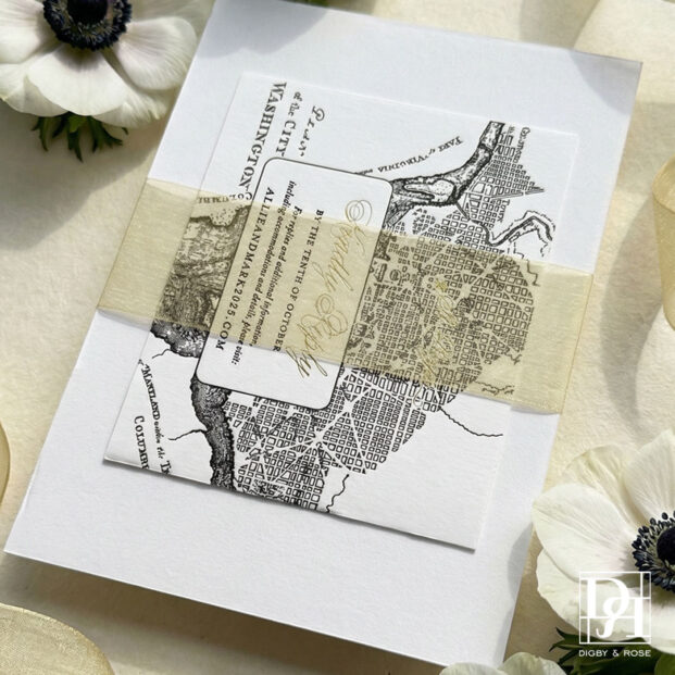 Letterpress wedding invitation with gold organdy ribbon belly band holding enclosure cards